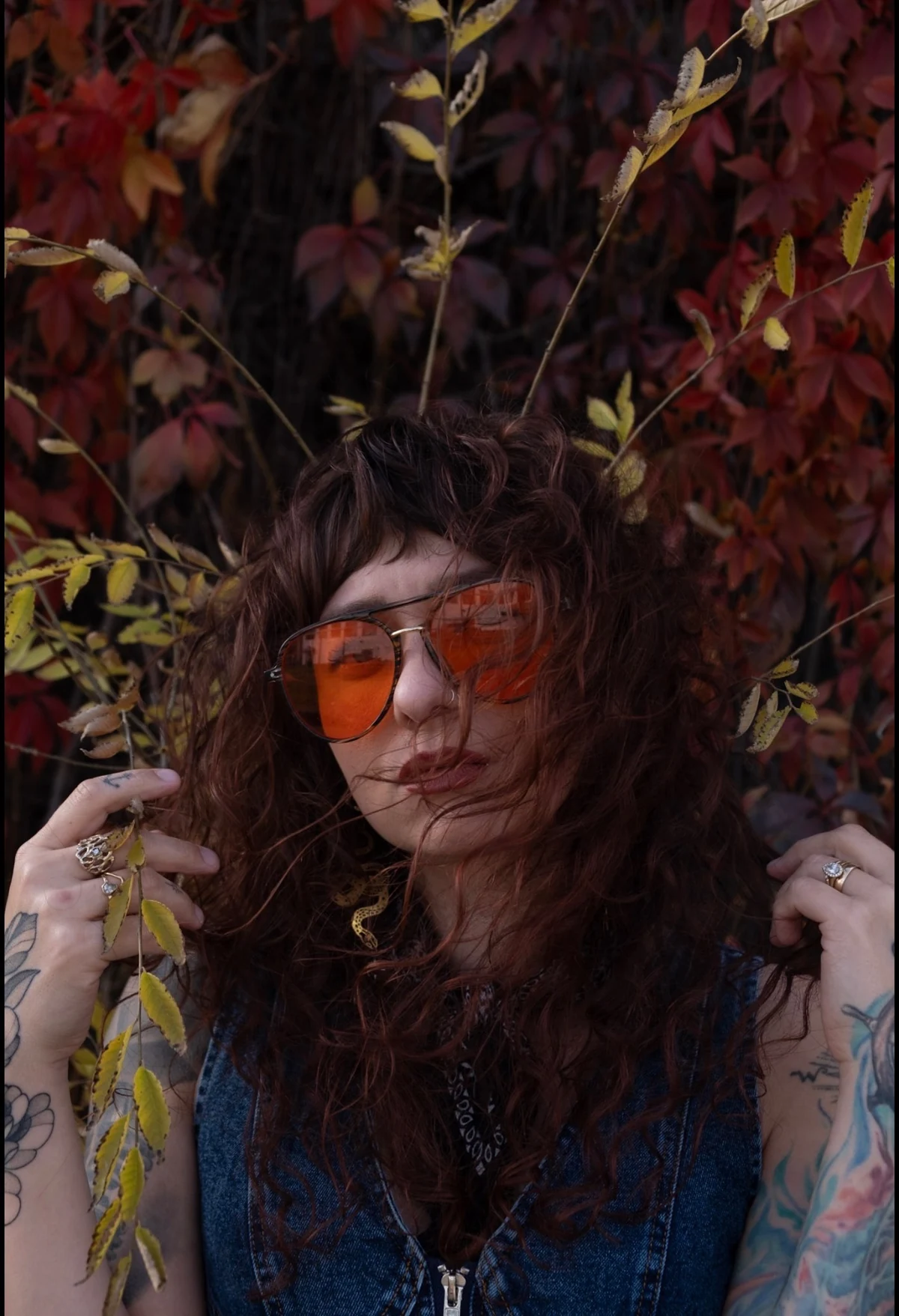 Tyra Whitson wearing orange glasses among autumn leaves